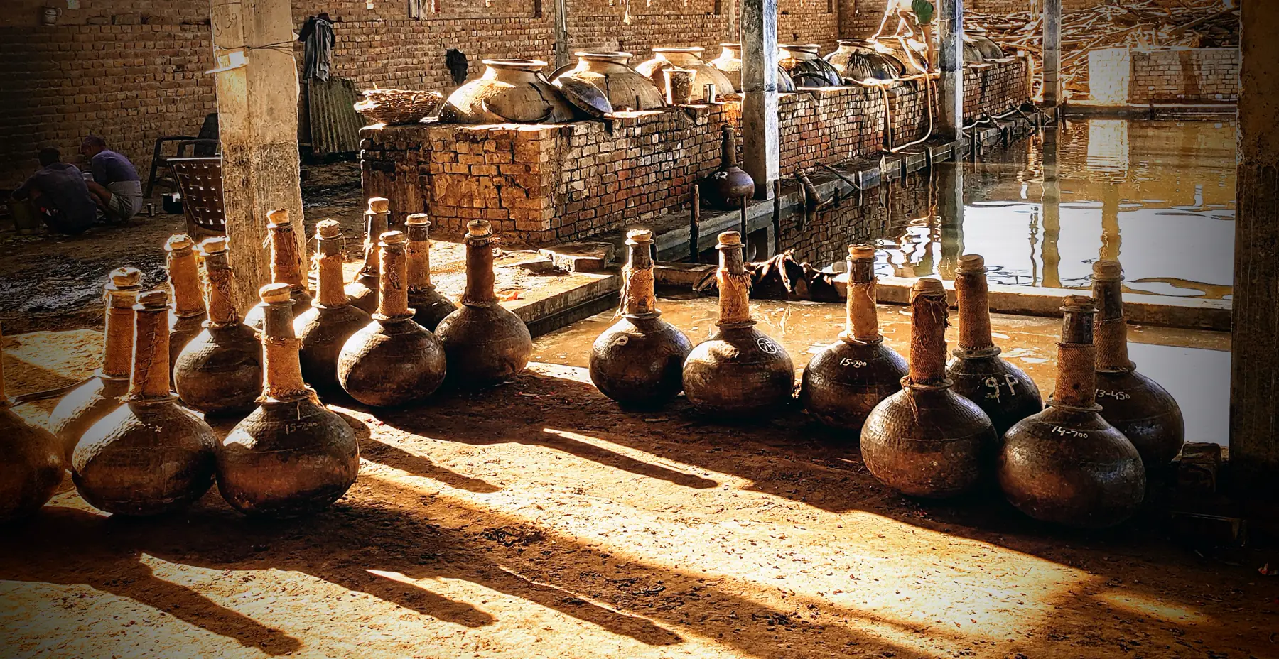 Row of copper bhapka receiving vessels in the Kannauj distillery